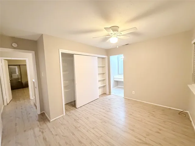 a view of an empty room with closet and a window