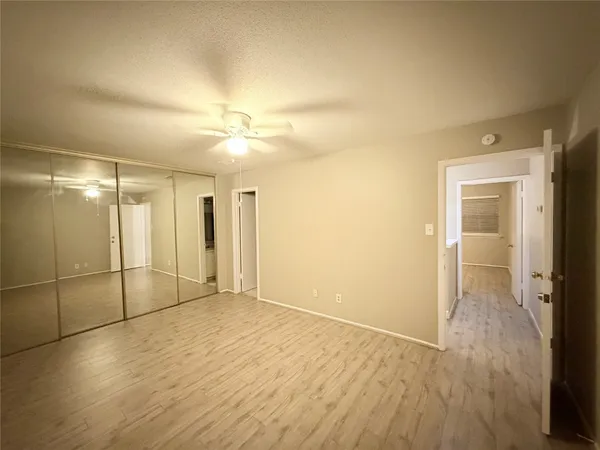 an empty room with wooden floor and a bathroom