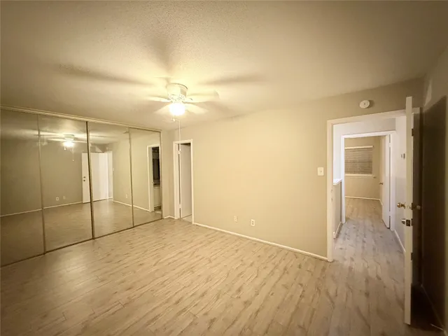 an empty room with wooden floor and a bathroom