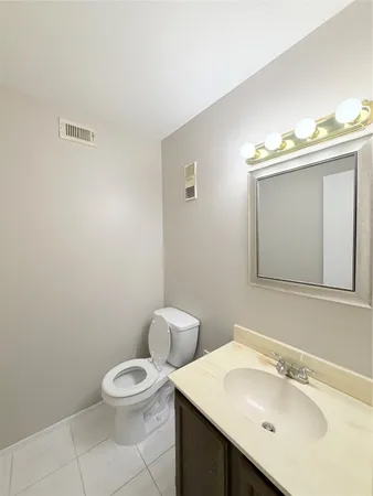 a bathroom with a sink mirror vanity and toilet