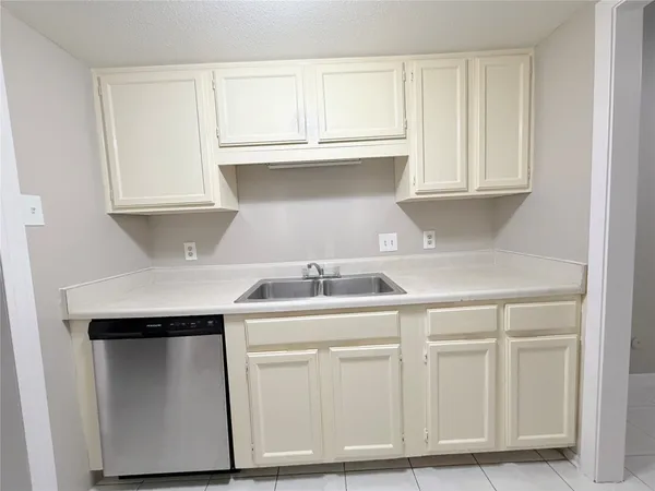 a kitchen with white cabinets and sink