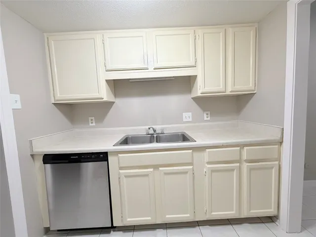 a kitchen with white cabinets and sink