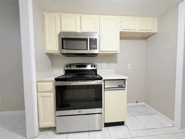 a kitchen with stainless steel appliances granite countertop a stove microwave and oven