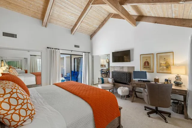 a bedroom with two beds and a flat screen tv