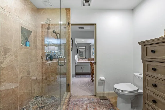 a bathroom with a sink a toilet and shower