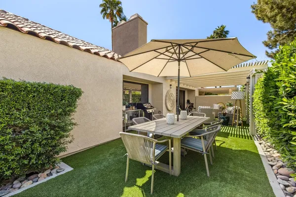 a kitchen with stainless steel appliances granite countertop a stove a refrigerator and a chair