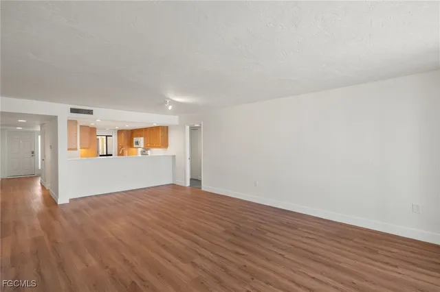a view of a kitchen with wooden floor and a window