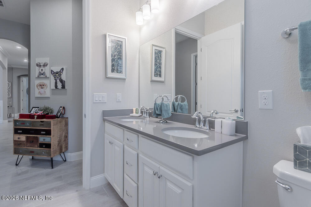191 Enrede Lane St. Augustine, FL 32095 - Photo 25 of 44 a bathroom with a granite countertop sink a toilet and a mirror