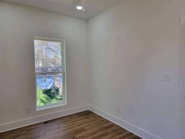 a view of room with window and wooden floor