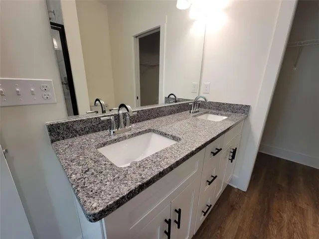 a bathroom with a granite countertop sink and a mirror