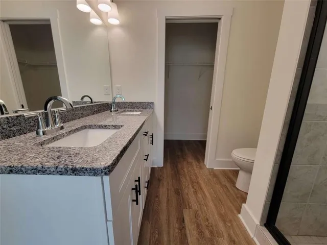 a bathroom with a granite countertop sink toilet and shower