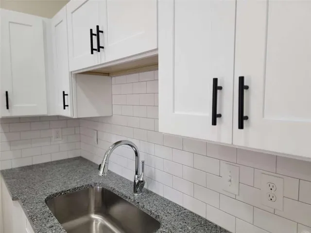 a kitchen with granite countertop a sink a granite counter tops and a stove