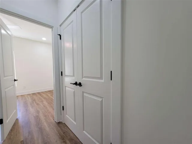 a view of a hallway with wooden floor