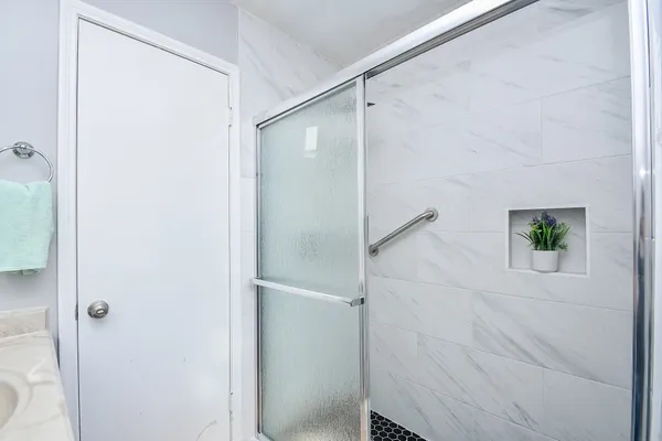 a bathroom with a shower and a glass door