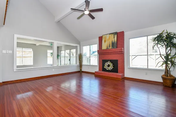 wooden floor fireplace and windows in an empty room