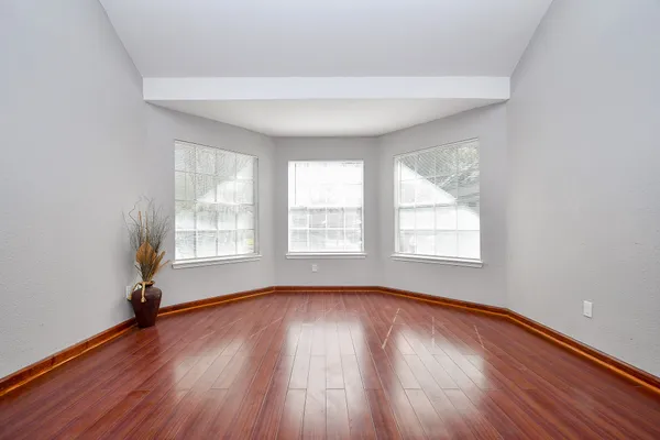 a view of an empty room with wooden floor