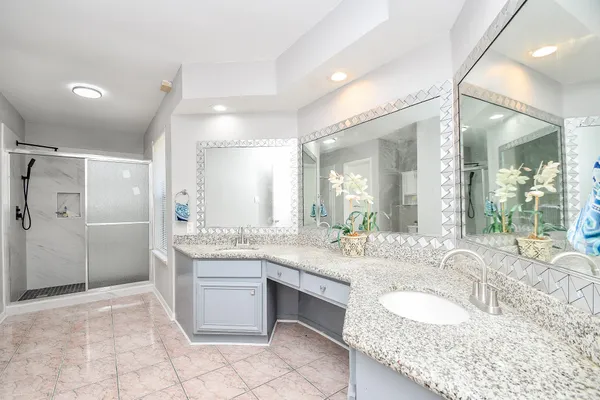 a bathroom with a granite countertop double vanity sink and a mirror