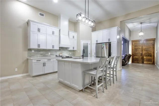a kitchen with kitchen island granite countertop a center island a sink stainless steel appliances and cabinets