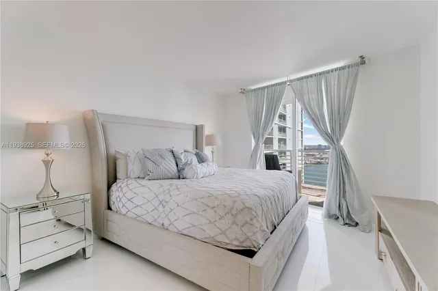 a bedroom with a bed and a large window