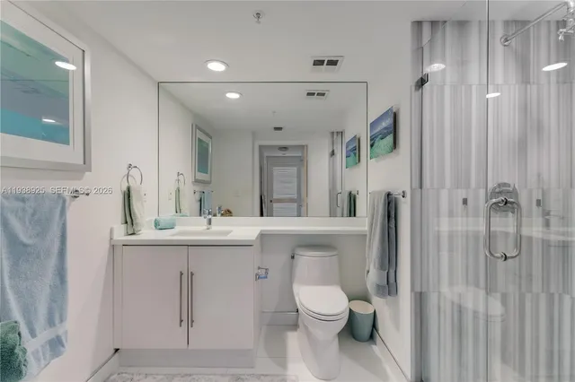 a bathroom with a sink a toilet and shower