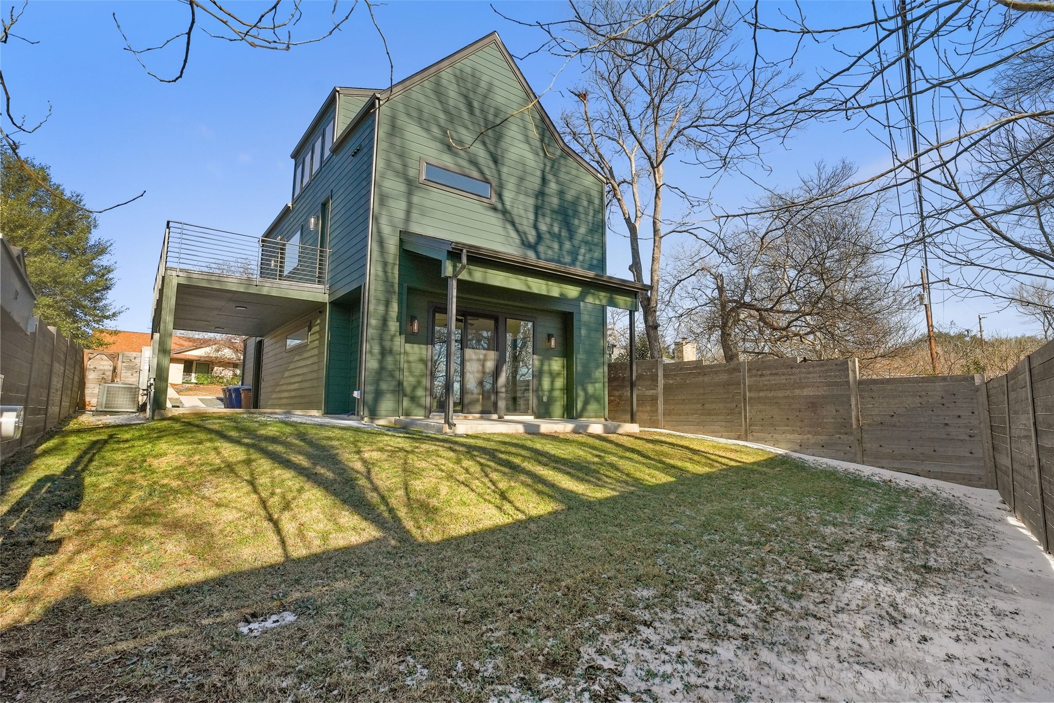 5109 Stone Gate Drive, Unit 2 Austin, TX 78721 - Photo 31 of 36 Spacious backyard featuring a sloped lawn and a modern vertical plank fence