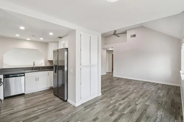 a view of a kitchen with a sink and a refrigerator