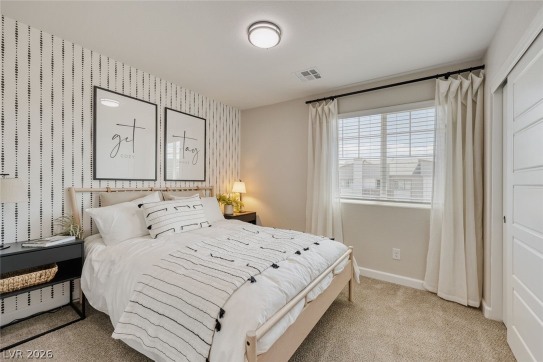 911 Cadence View Way Henderson, NV 89011 - Photo 11 of 28 This cozy bedroom features plush carpeting and a large window with blinds for natural light.