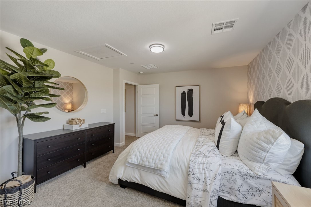 911 Cadence View Way Henderson, NV 89011 - Photo 14 of 28 This spacious bedroom offers a tranquil retreat with soft carpet flooring.