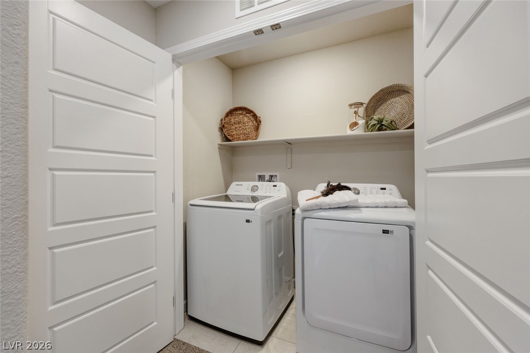 911 Cadence View Way Henderson, NV 89011 - Photo 18 of 28 This dedicated laundry space offers convenience and functional storage.