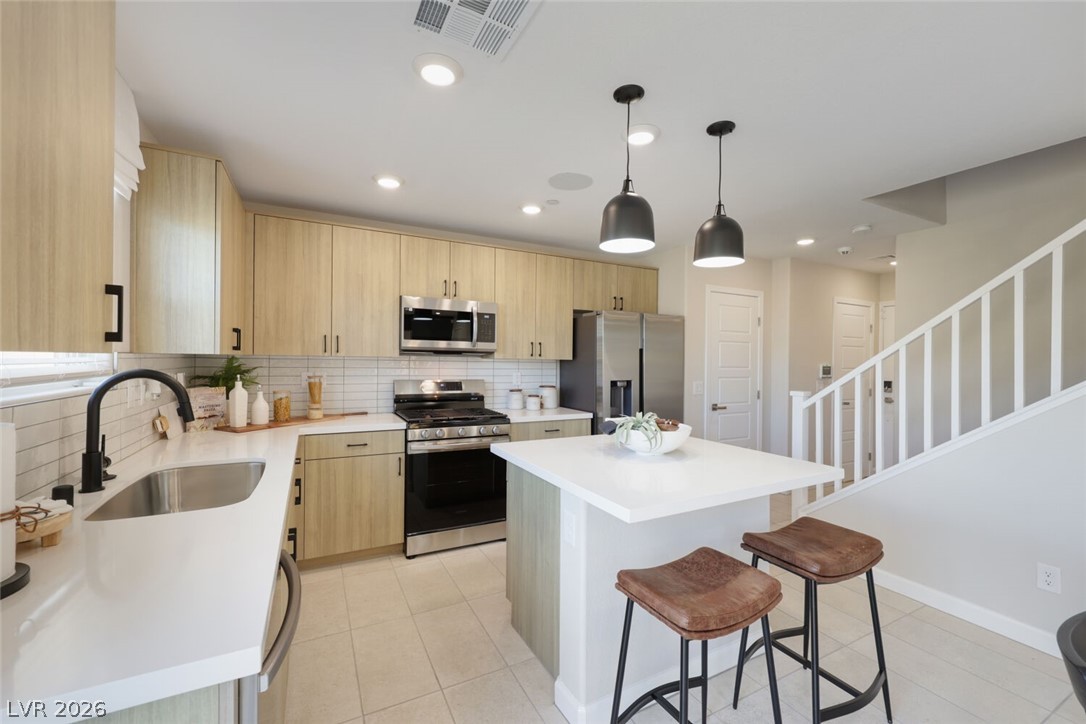 911 Cadence View Way Henderson, NV 89011 - Photo 2 of 28 This modern kitchen features a spacious island, sleek appliances, and easy access to the adjacent living spaces.