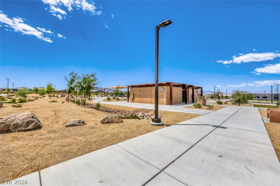 911 Cadence View Way Henderson, NV 89011 - Photo 23 of 28 This desert landscape features a modern community building and clear blue skies.