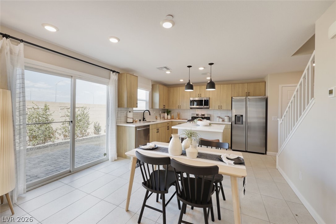 911 Cadence View Way Henderson, NV 89011 - Photo 3 of 28 Bright open-concept kitchen and dining area with modern finishes and convenient outdoor access.