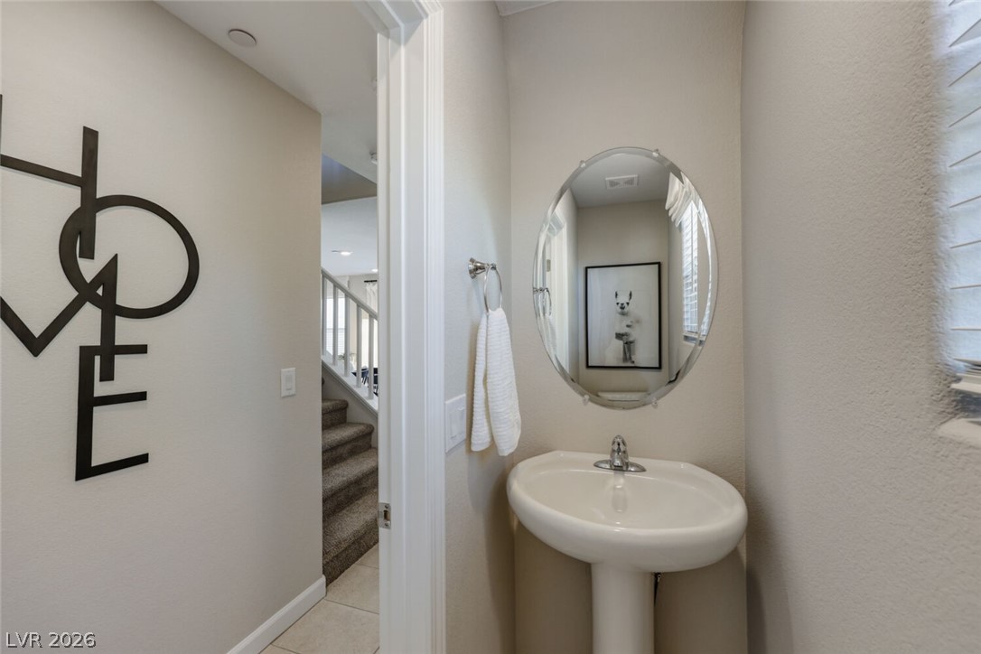 911 Cadence View Way Henderson, NV 89011 - Photo 8 of 28 This convenient bathroom features a pedestal sink and elegant oval mirror.