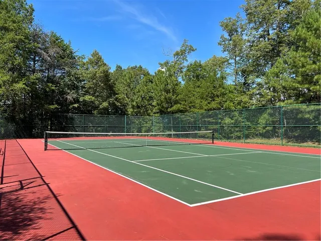 a front view of a house with garden and trees