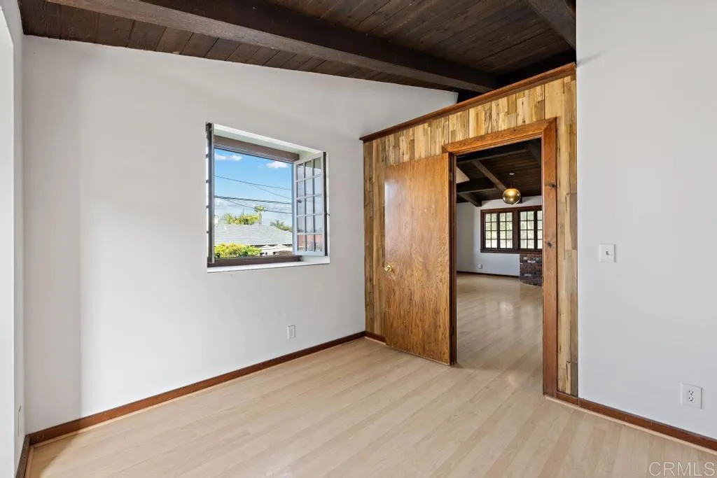 1046 Neptune Avenue Encinitas, CA 92024 - Photo 46 of 49 a view of an empty room with wooden floor and a window
