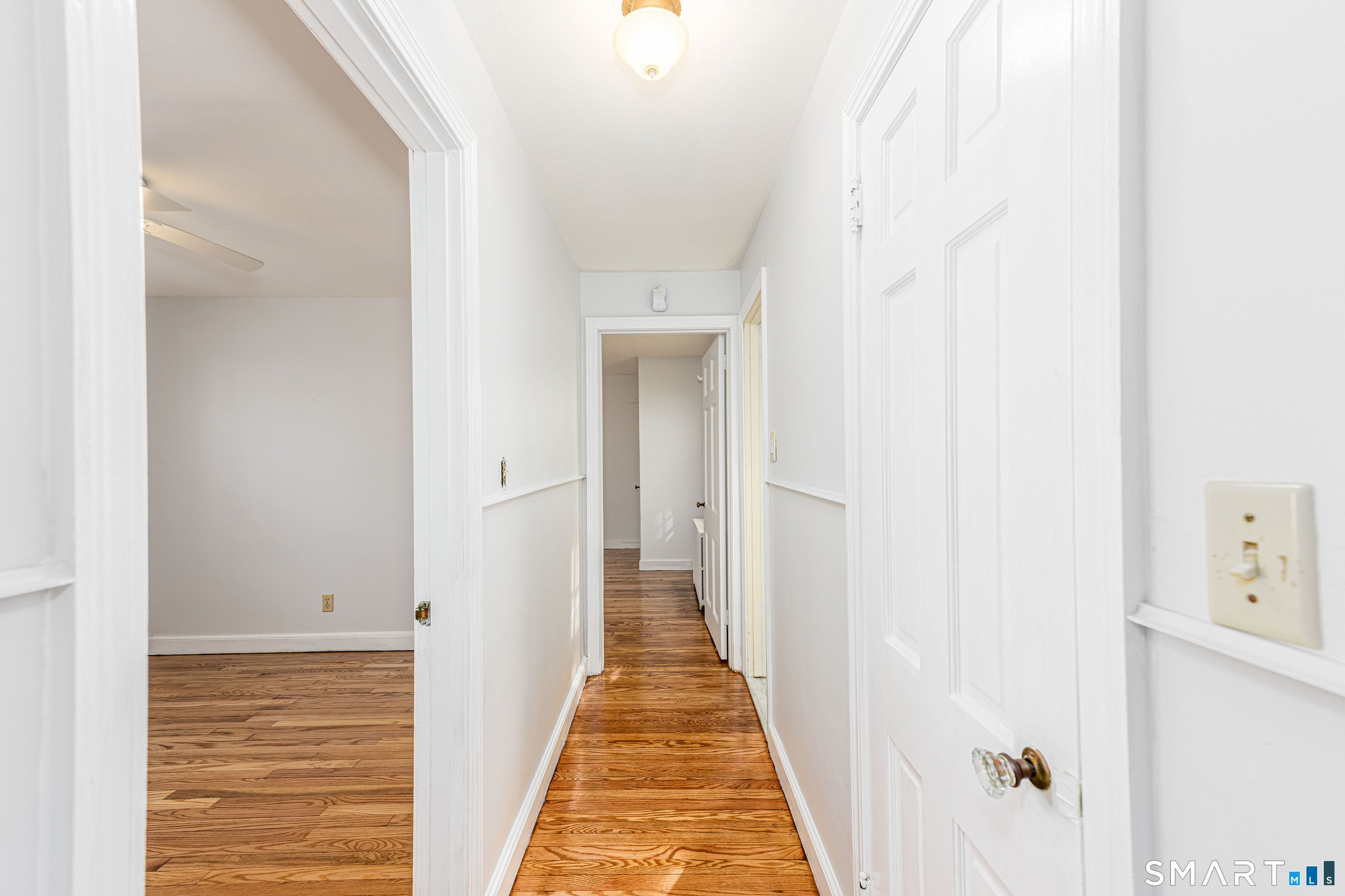 84 Piper Road Hamden, CT 06514 - Photo 17 of 28 a view of a hallway with wooden floor and a bathroom