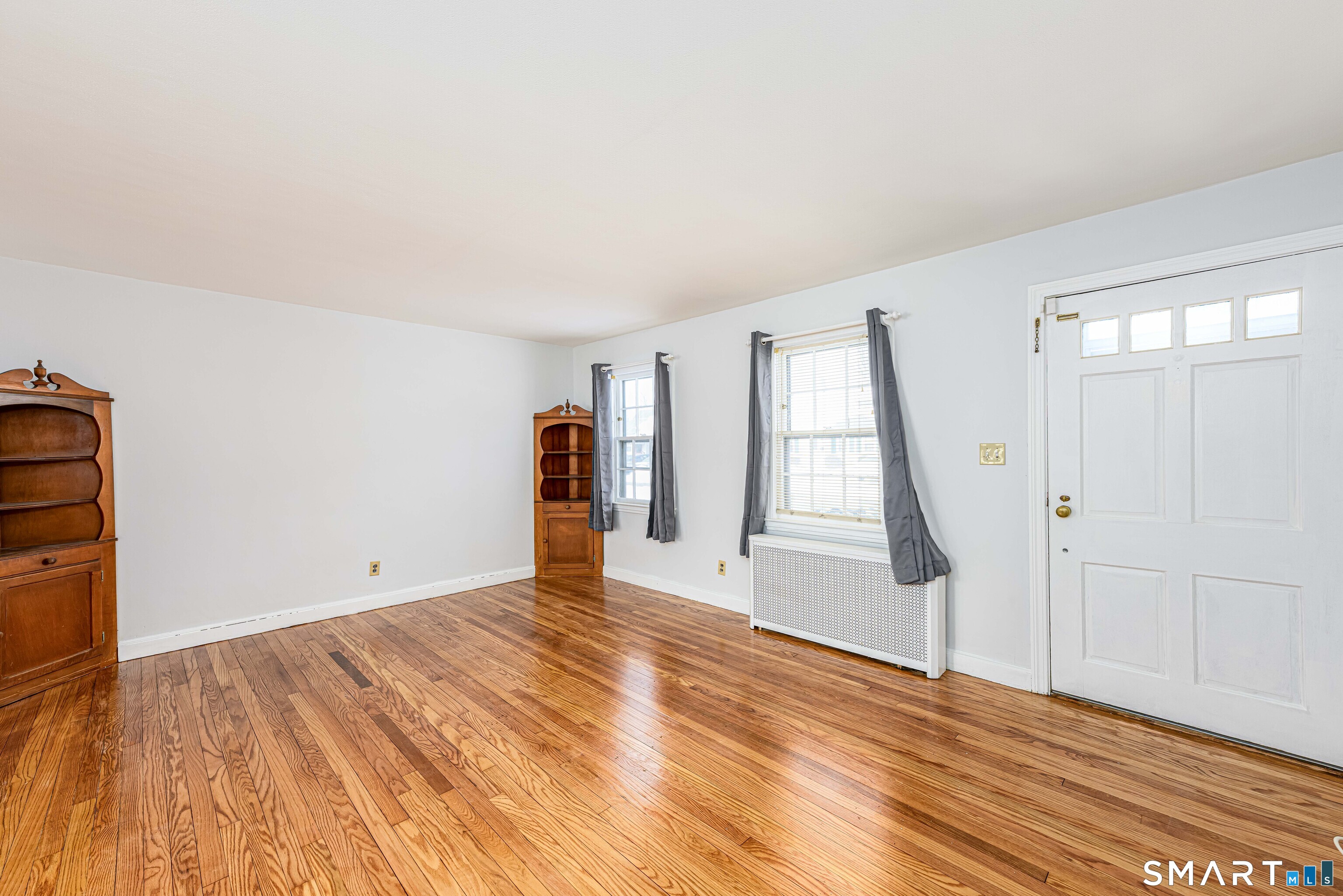 84 Piper Road Hamden, CT 06514 - Photo 4 of 28 a view of an empty room with wooden floor and a window
