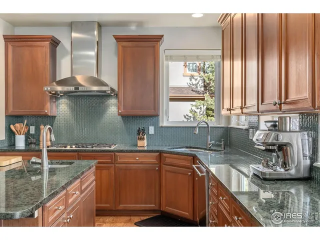 a kitchen with stainless steel appliances granite countertop a sink a stove and cabinets