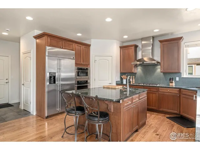 a kitchen with stainless steel appliances granite countertop a sink and a refrigerator