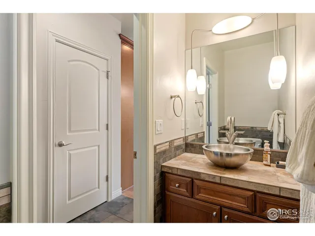 a bathroom with a granite countertop sink a mirror and a shower