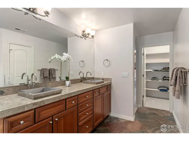 a bathroom with a granite countertop sink a mirror and a shower