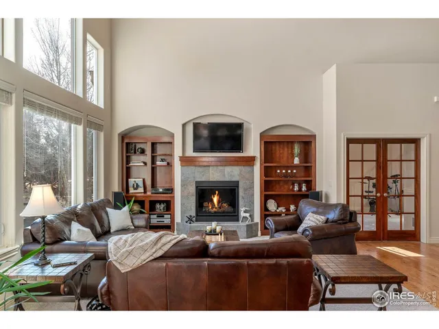 a living room with furniture large window and fireplace