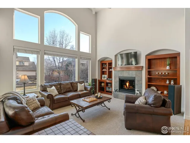 a living room with furniture a large window and a fireplace