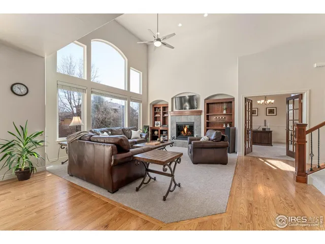 a living room with furniture large window and wooden floor