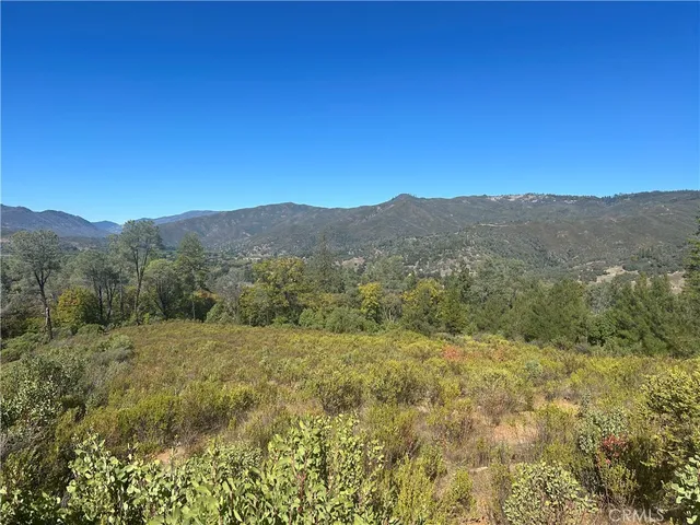 a view of a mountain range with trees in the background