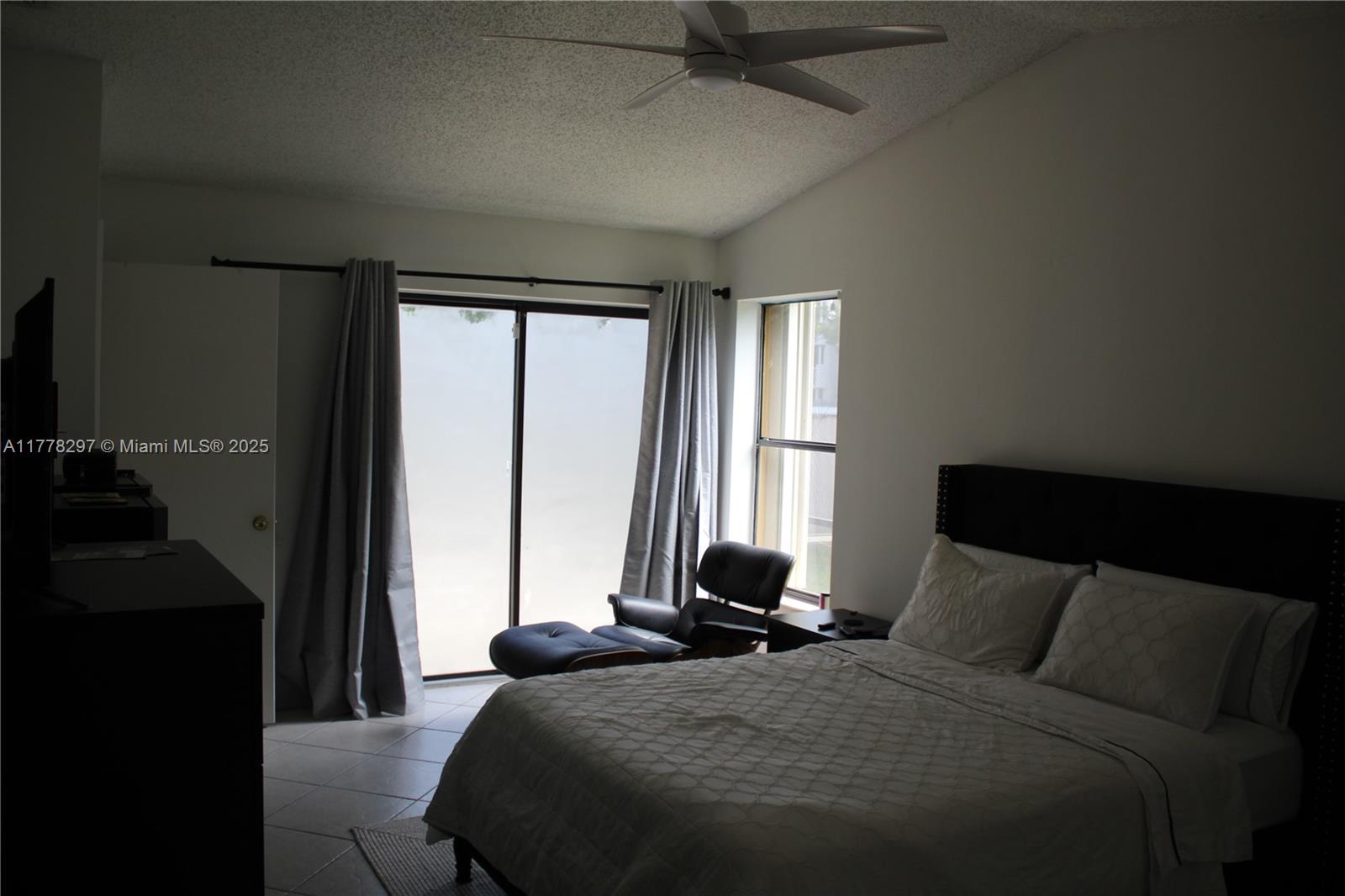 17320 Northwest 62nd Place Hialeah, FL 33015 - Photo 6 of 27 a bedroom with a bed and a large window
