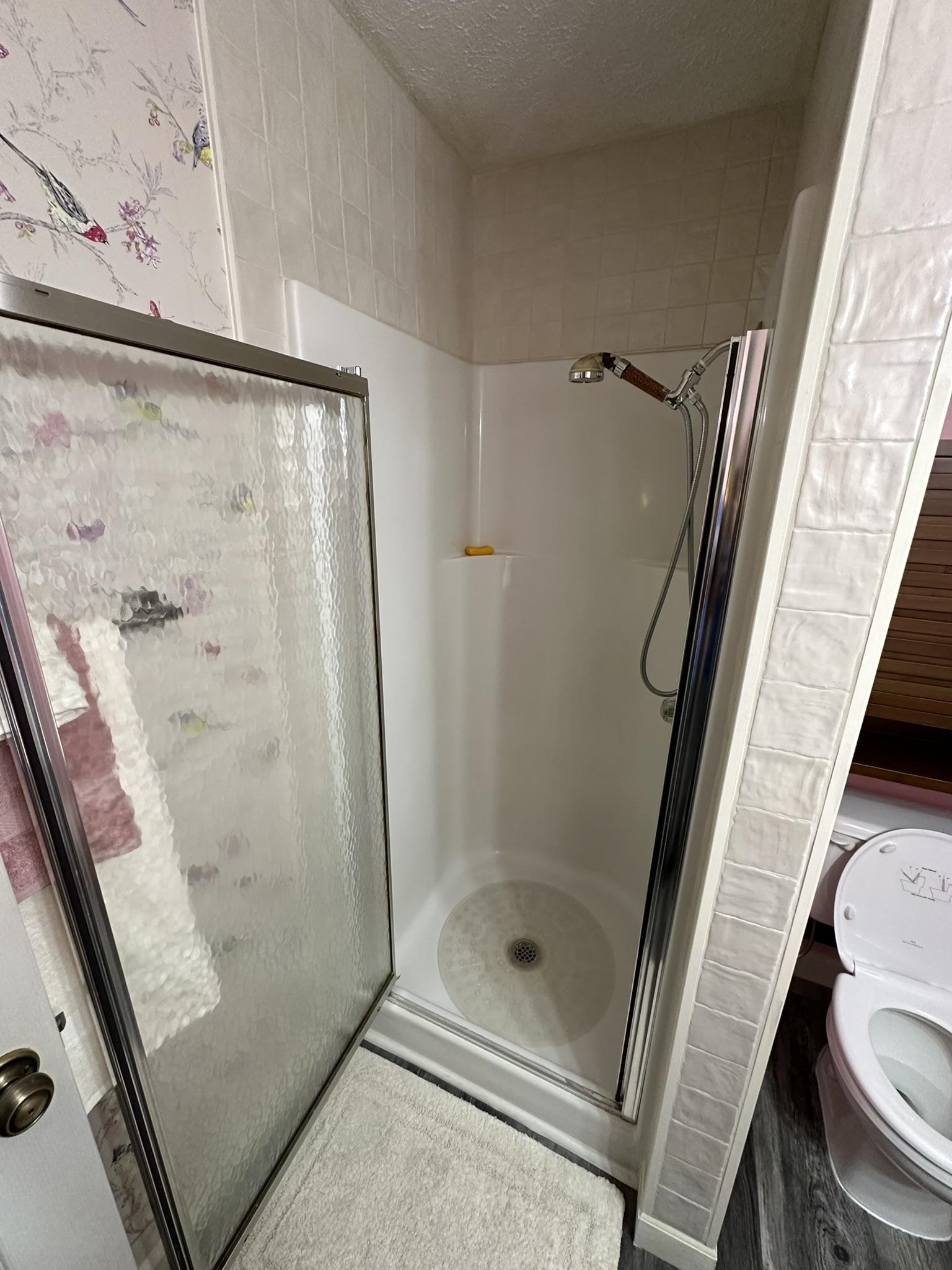 576 Carroll Hollow Road Waynesboro, TN 38485 - Photo 23 of 40 a bathroom with a glass door shower and toilet