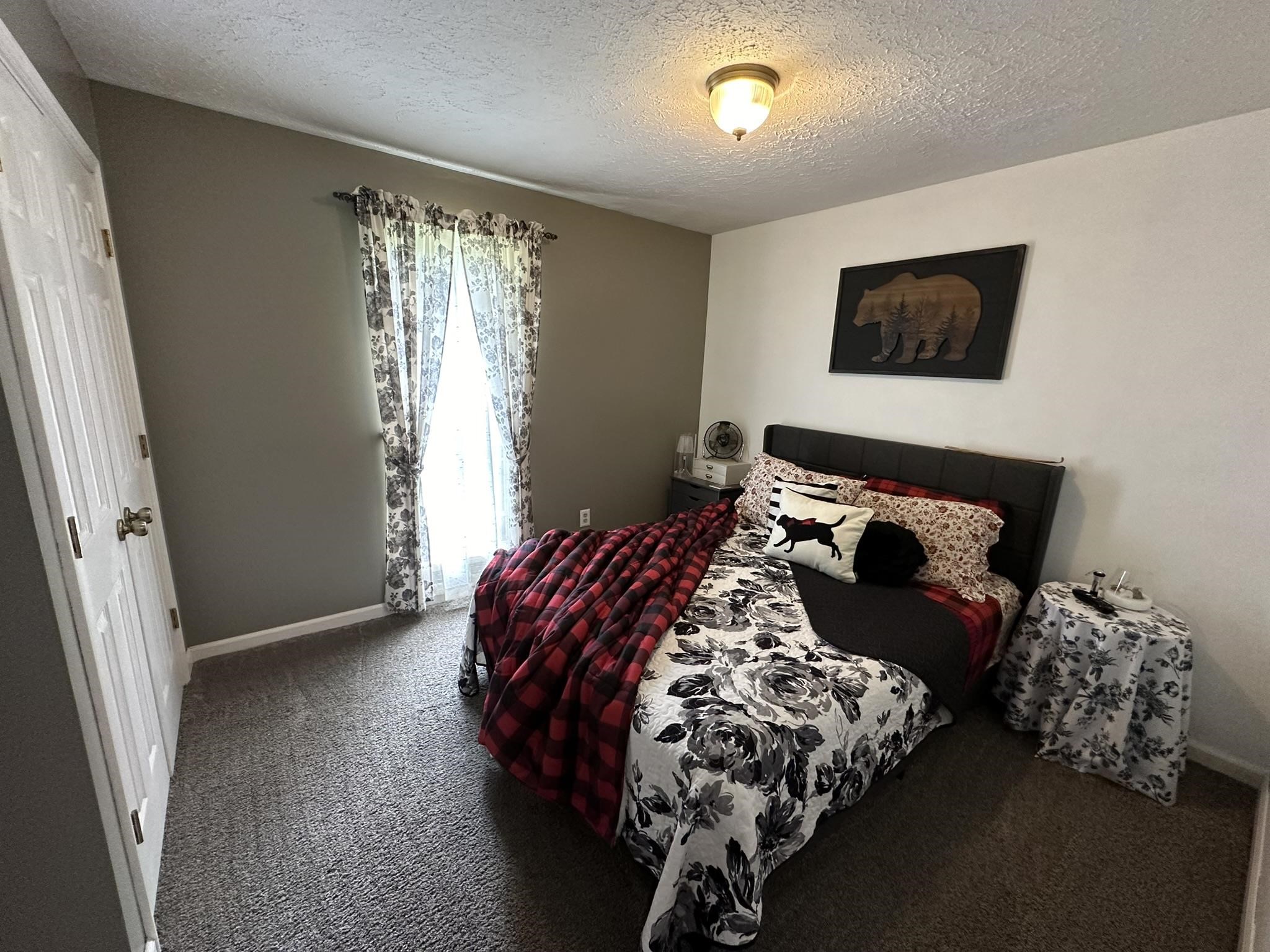 576 Carroll Hollow Road Waynesboro, TN 38485 - Photo 25 of 40 a bed sitting in a bedroom next to a window