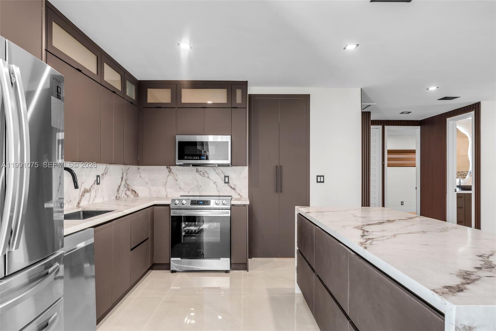 7920 Southwest 132nd Street Pinecrest, FL 33156 - Photo 11 of 45 a large kitchen with stainless steel appliances a sink and a refrigerator
