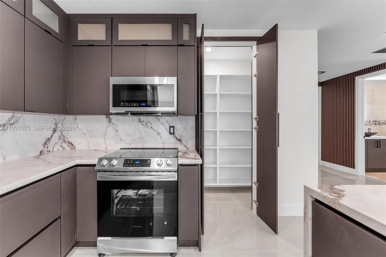 7920 Southwest 132nd Street Pinecrest, FL 33156 - Photo 13 of 45 a kitchen with granite countertop a stove and a microwave